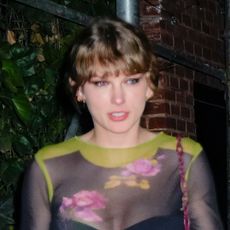 Taylor Swift wears a sheer floral top and carries a red bag while on a date with Travis Kelce