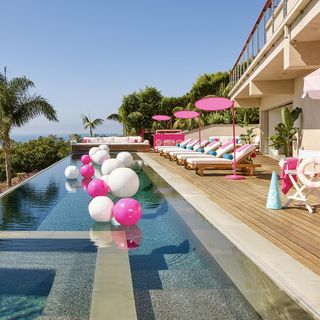 swimming pool with beach and pink balloon