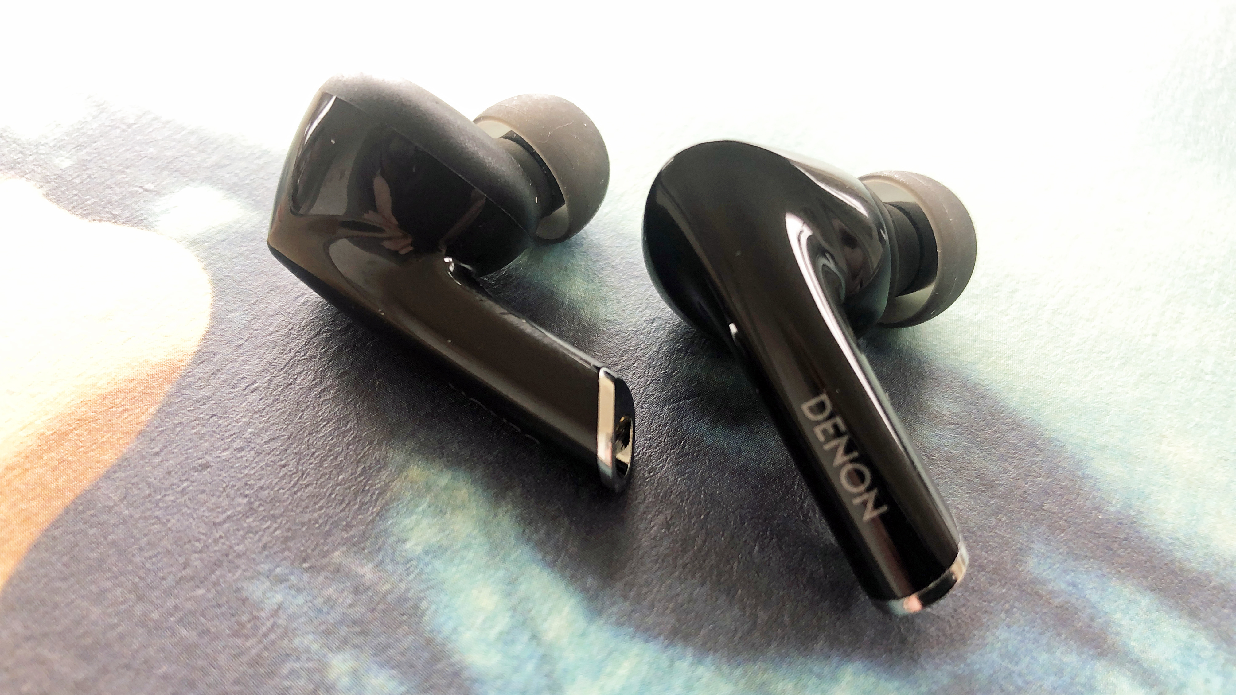 a closeup of the denon ah-c830nwc true wireless earbuds