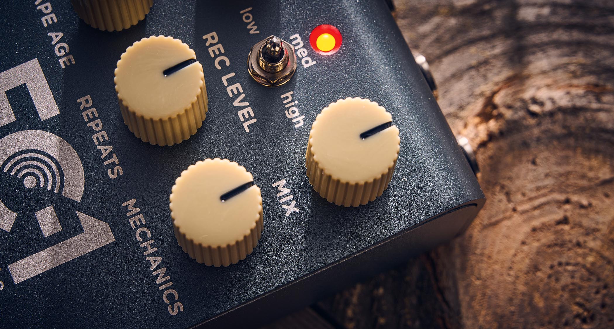 Strymon EC-1 Single Head dTape Echo: the metallic gray box has cream dials, an LED that lights up blue and/or red, and is photographed here against a wooden background.