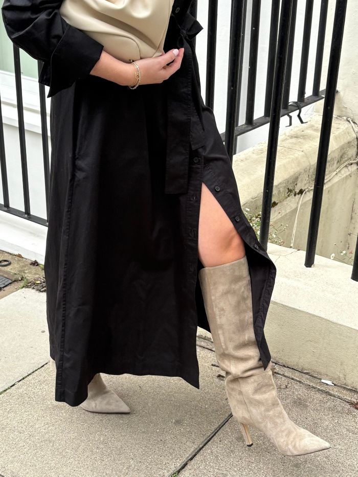 Woman wears black dress and grey suede knee high boots