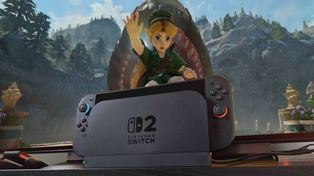 Switch 2 sitting in dock in front of TV with Zelda Ocarina of Time trailer on screen featuring Link in front of Jabu-Jabu.