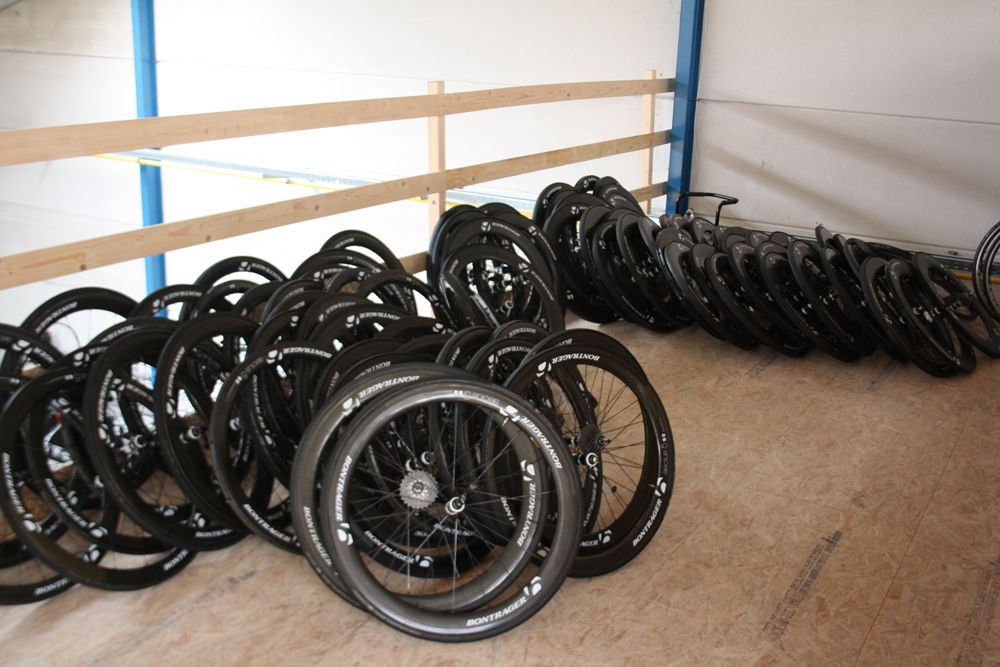 Old Bontrager road wheels line the upper deck of the team's service course