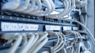 Close up of networks server rack with internet patch cord cables connected to patch panel.