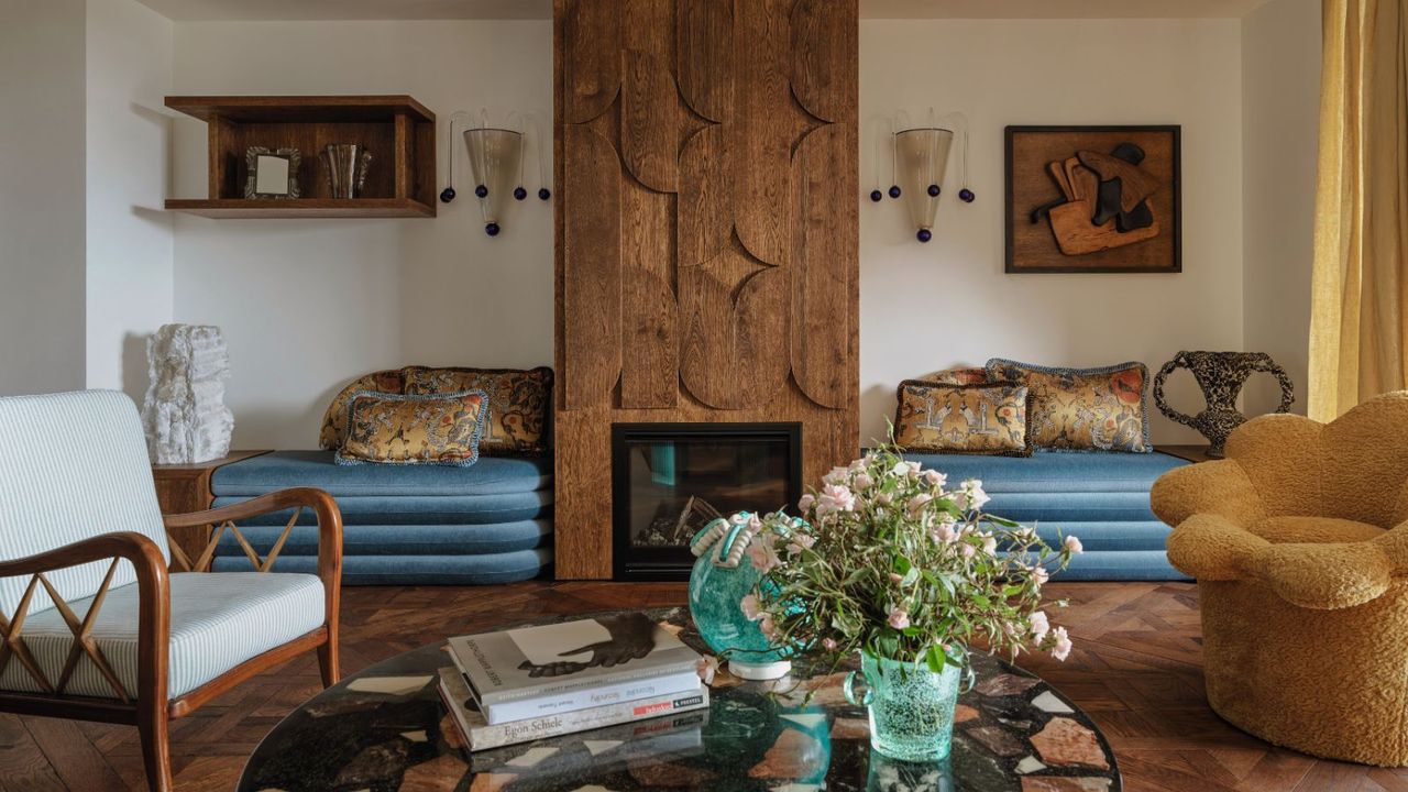 living area with wooden floorboards and inbuilt blue velvet seating and terrazzo marble coffee table