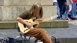 Young busker playing guitar