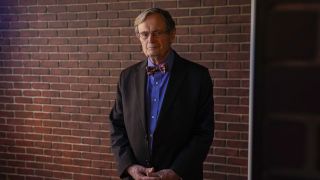 David McCallum as Donald "Ducky" Mallard standing in front of brick wall on NCIS