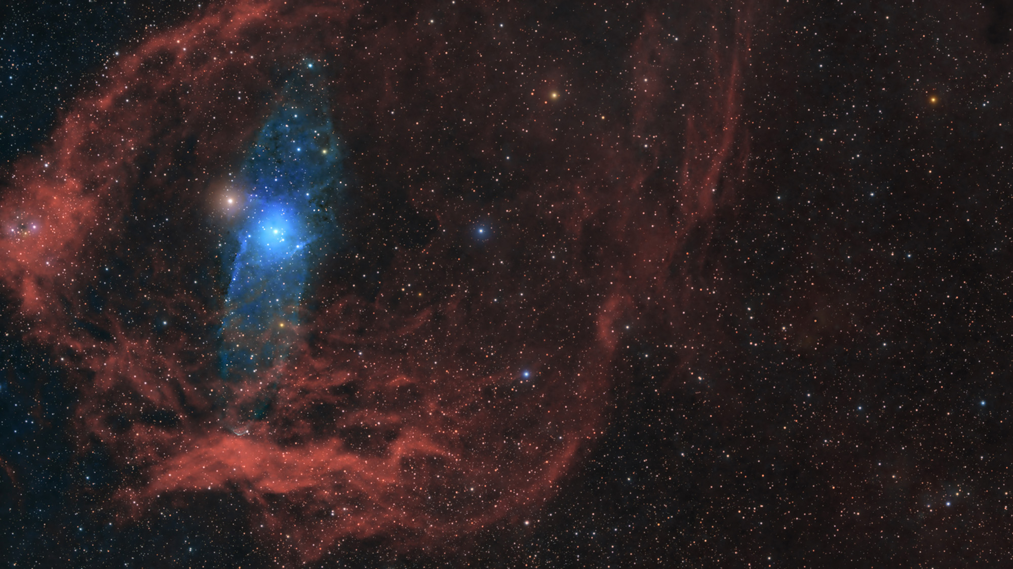 A blue glowing star is surrounded by red gas in deep space.