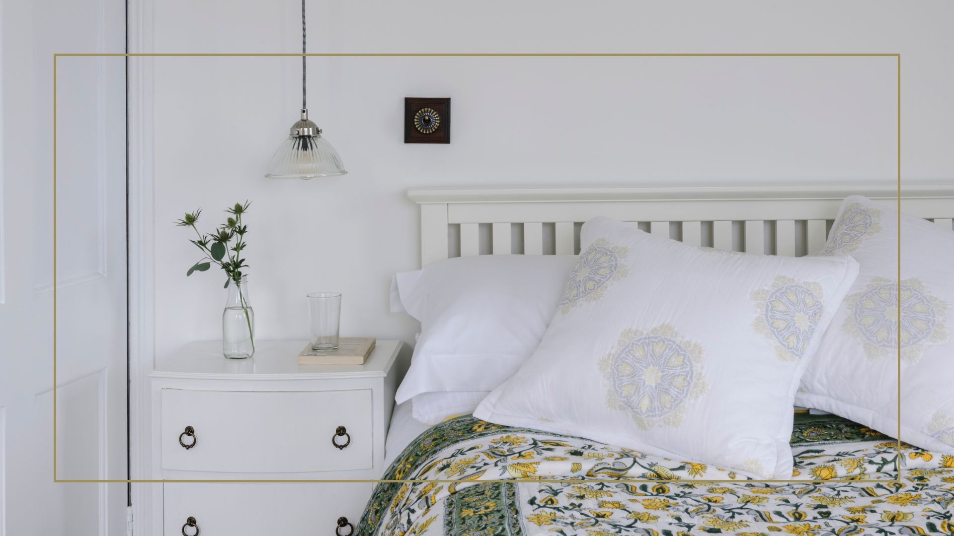 white bedroom with a white wooden bed frame white bedside table with a  green and yellow bedspread