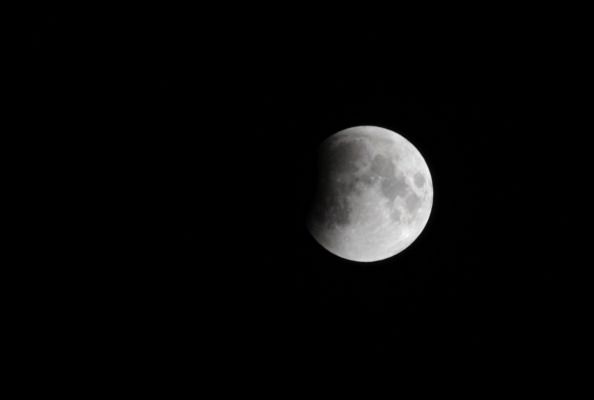 The moon eclipsed by Earth&amp;#039;s shadow.