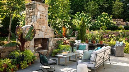 landscaped and planted backyard with seating area and pizza oven