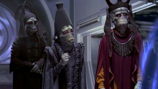 Three Neomoidians speak to a hologram-based character in one of the Star Wars prequel movies