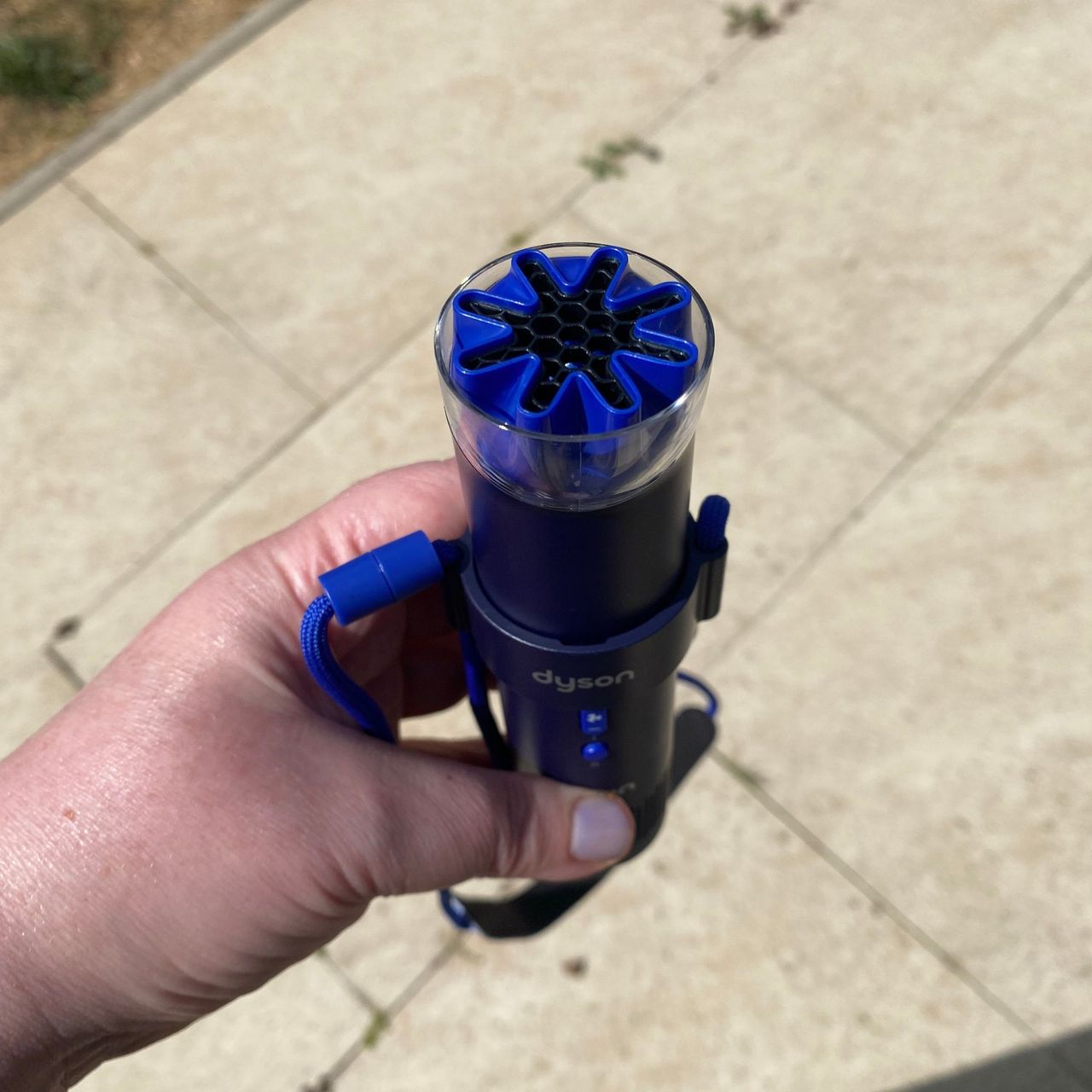 Holding the Dyson HushJet Mini Cool fan with the head twisted to suit the neck dock