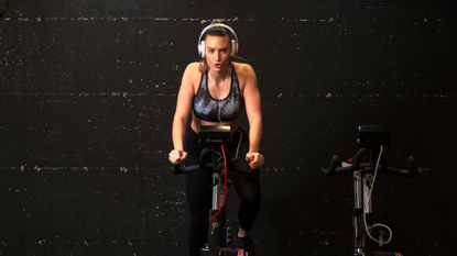 Female cyclist wearing headphones for cycling