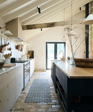 Stone floor, grey rug, white drawers, wooden beam