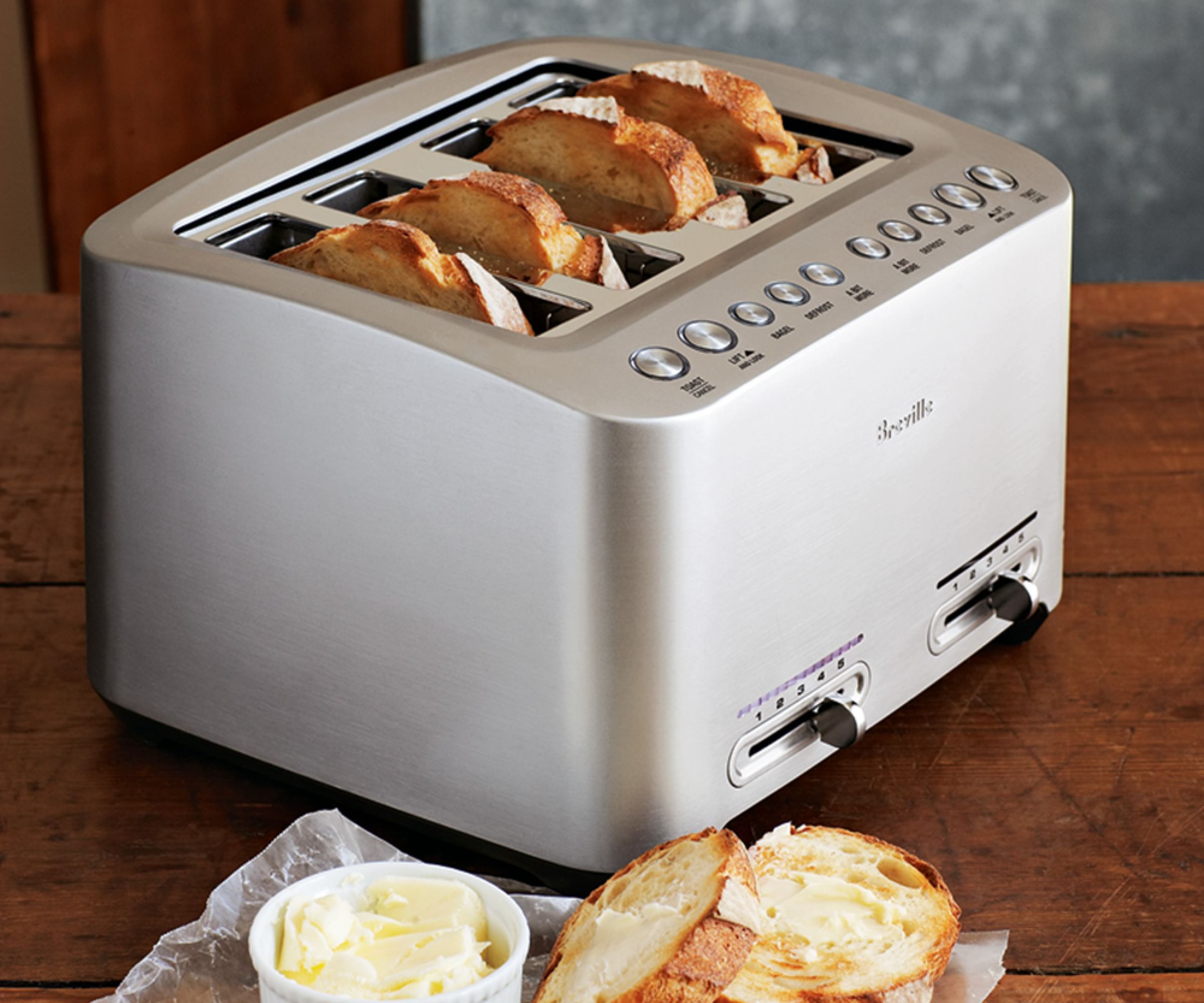 A Breville Die Cast 4-Slice Toaster with artisan bread and butter