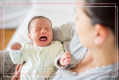 Mother holding a crying baby - one of the signs of colic in newborns