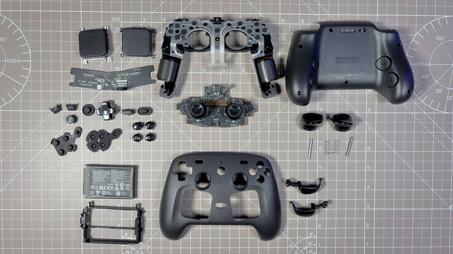 The Steam Controller on a desk during a teardown, with various parts removed.