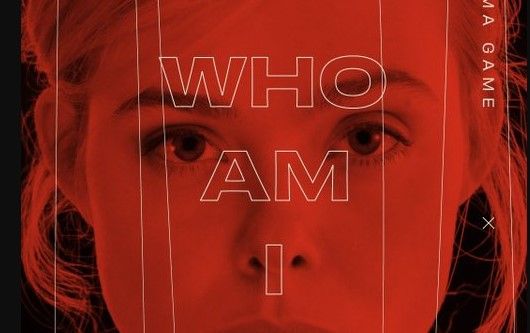 close up of actress Elle Fanning&#039;s face in red cast with text &quot;Who am I?&quot; overlaid.