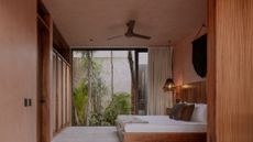 A bedroom with pink walls and black wall hanging