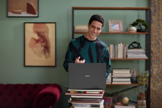 Ein Mann mit einem LG Gram Laptop, der auf einem Stapel Bücher steht.