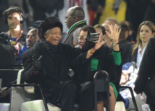Former South African president Nelson Mandela and his wife Graça Machel wave to fans ahead of the 2010 World Cup final in South Africa.
