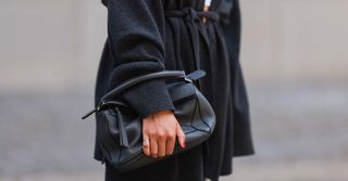 woman wearing a black coat and classic bag