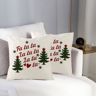 Christmas pillows that say Fa la la la la on a white sofa in a grey living room