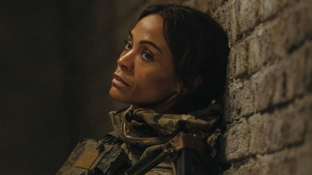 Zoe Saldana sits slumped against the wall