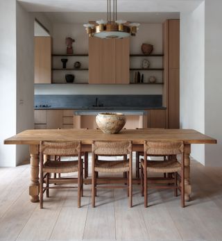 a modern rustic dining room with rush chairs