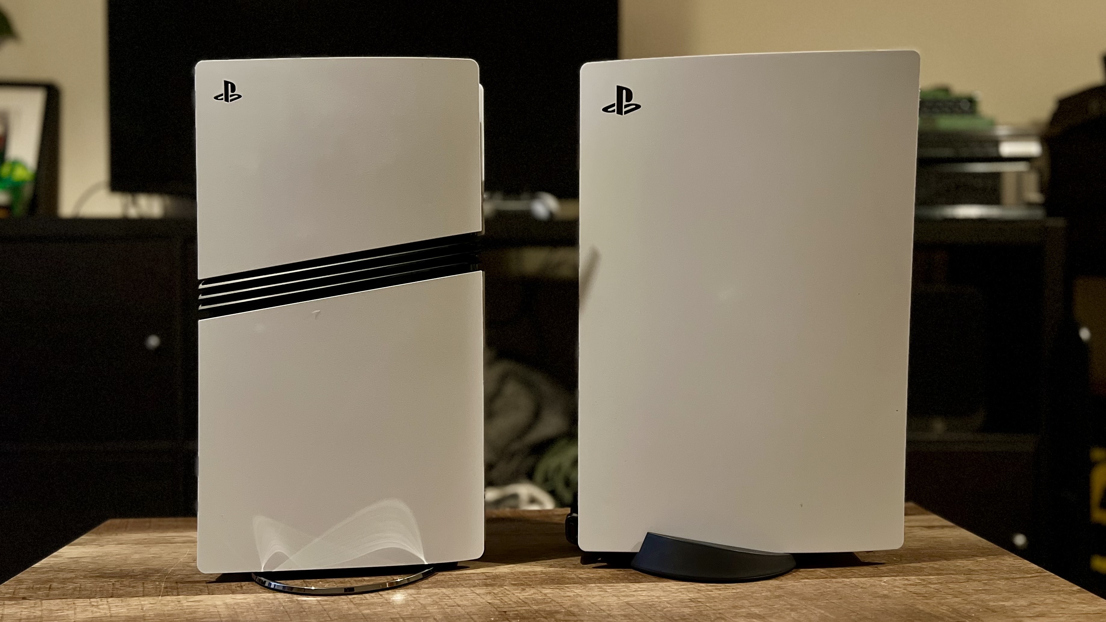 PS5 Pro and PS5 original console side on on a wooden table