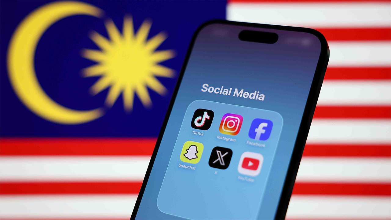 iPhone screen with six social media apps in front of Malaysian flag