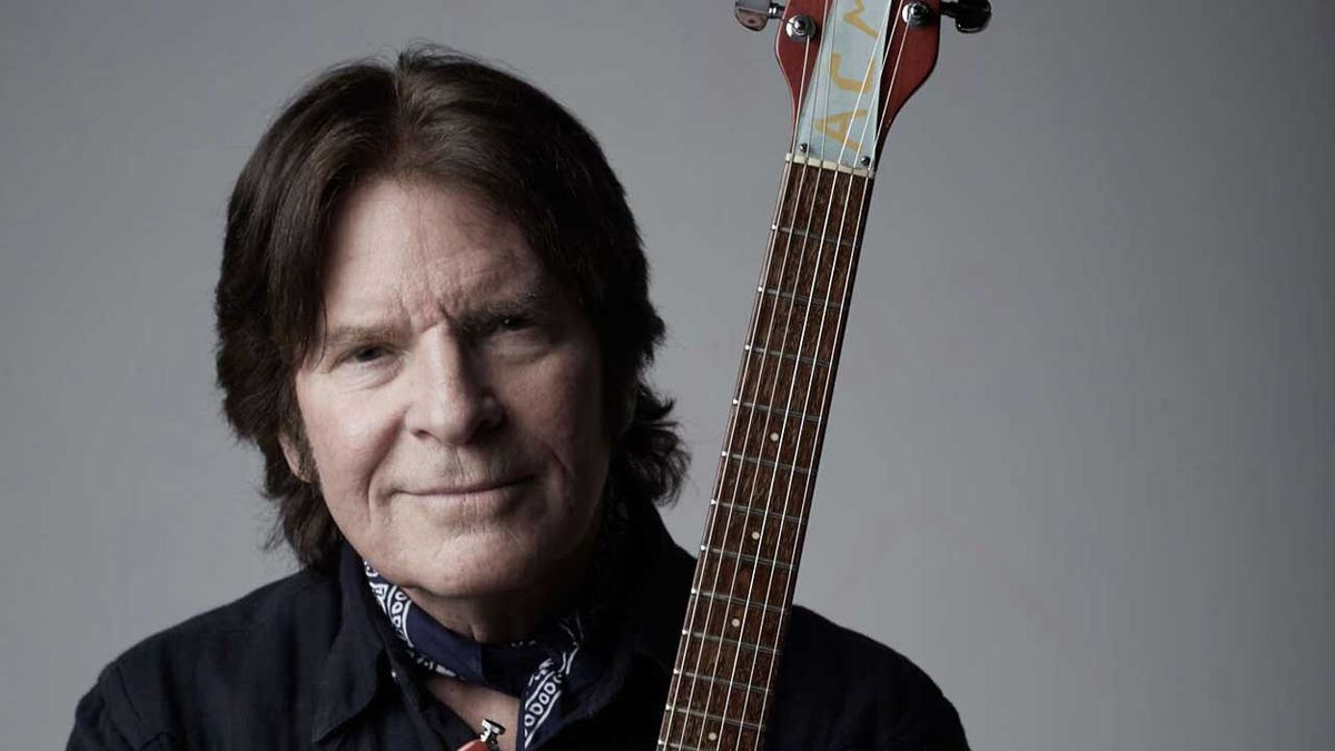 John Fogerty holding a Rickenbacker guitar (studio portrait)