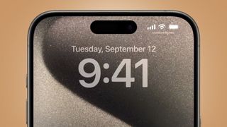 Overdelen av en Apple iPhone 15 Pro Max vises mot en beige bakgrunn.