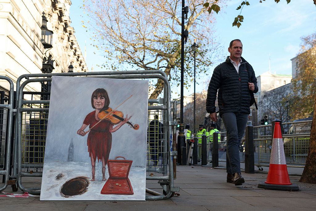 A pedestrian walks past a painting of Rachel Reeves by political satire artist Kaya Mar, along a street in central London on November 26, 2025