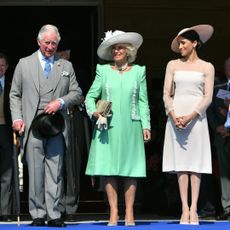 King Charles, Queen Camilla and Meghan Markle standing in a row