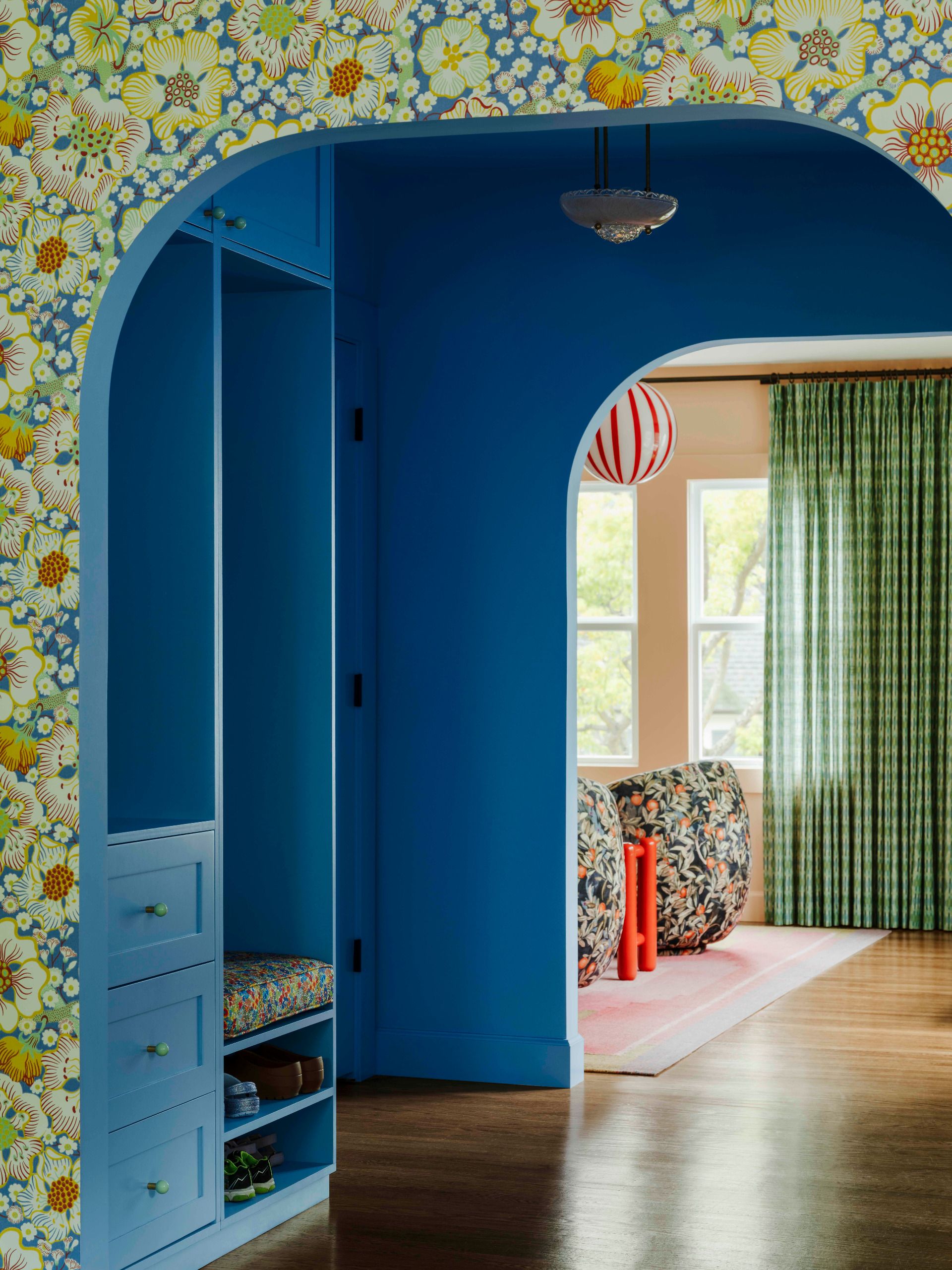 A contemporary entryway with bold colour and pattern, with further examples of creative decoration beyond
