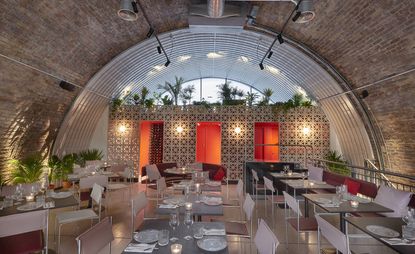 Bala Baya restaurant, arched exposed brick ceiling, chrome and leather stools and banquettes, breezeblock fresco with burnt orange doors