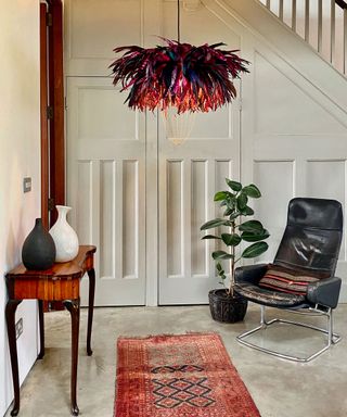 entryway with concrete floor and feather statement pendant light