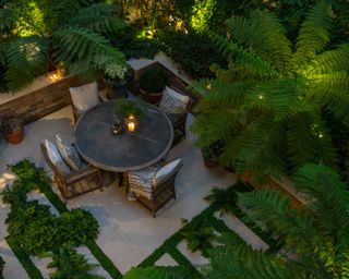 lush tropical planting and lighting in a small courtyard garden