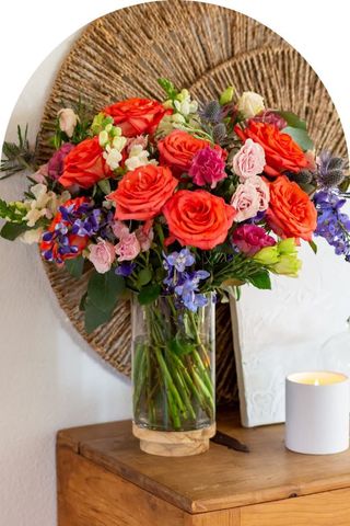 A colorful bouquet of various flowers in a clear vase.