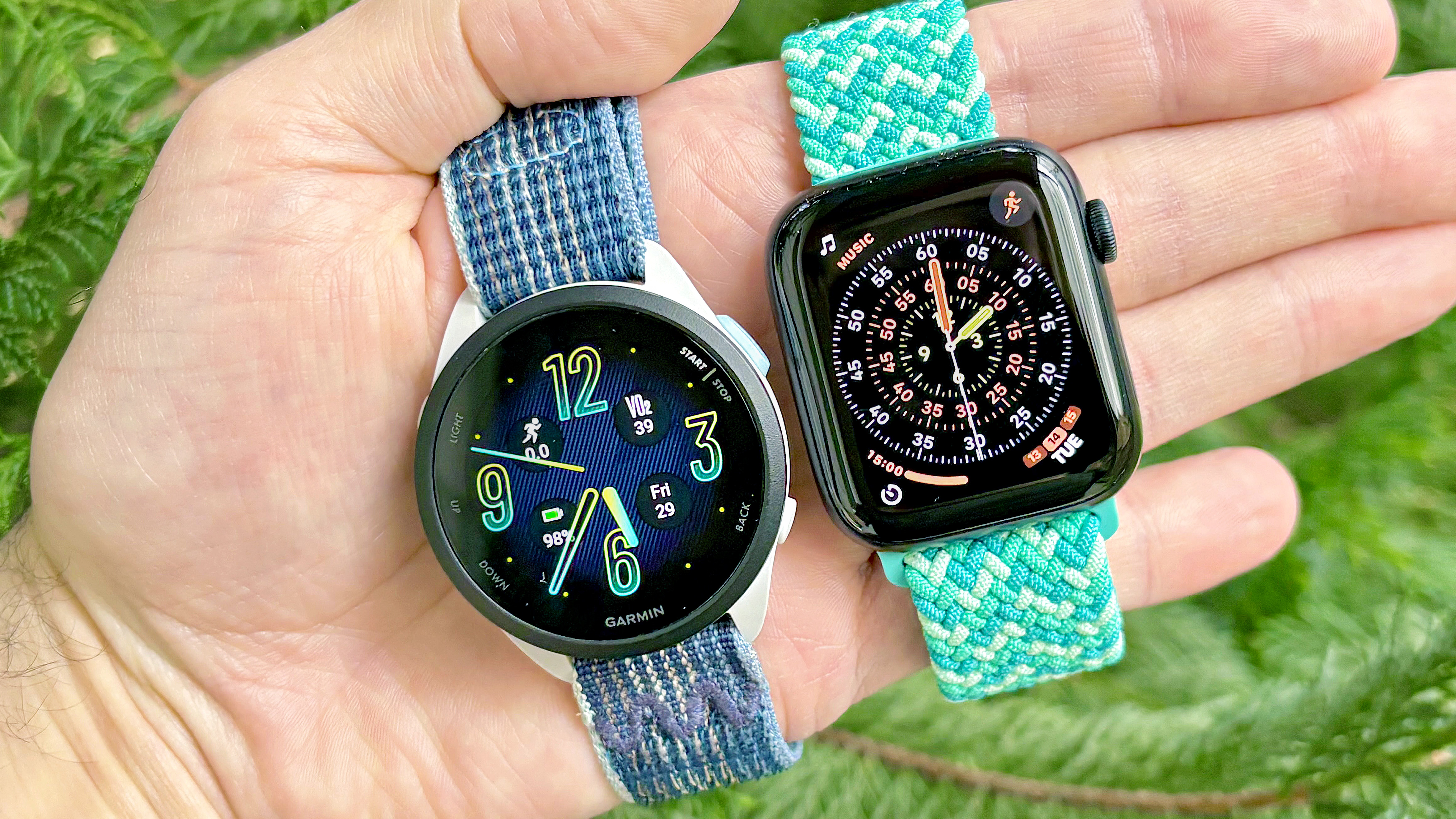 Close-up of the Garmin Forerunner 165 next to the Apple Watch SE 3