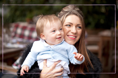 a mother smiling and holding her baby