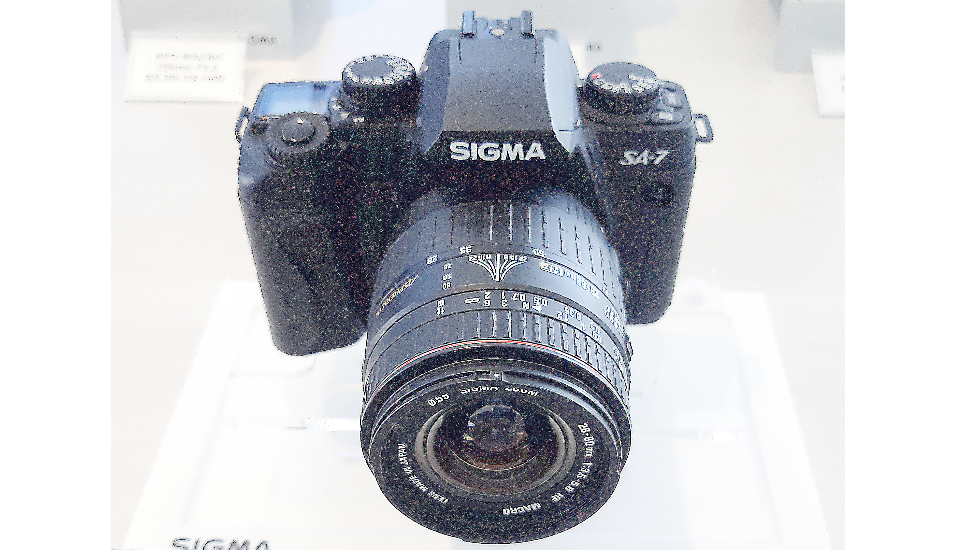 Sigma SA-7 (2001). Replacement for the SA-5 with restyled body, phase-detect AF with updated algorithms, eight-segment multi-zone metering, built-in flash, LCD info screen, auto exposure bracketing and more.