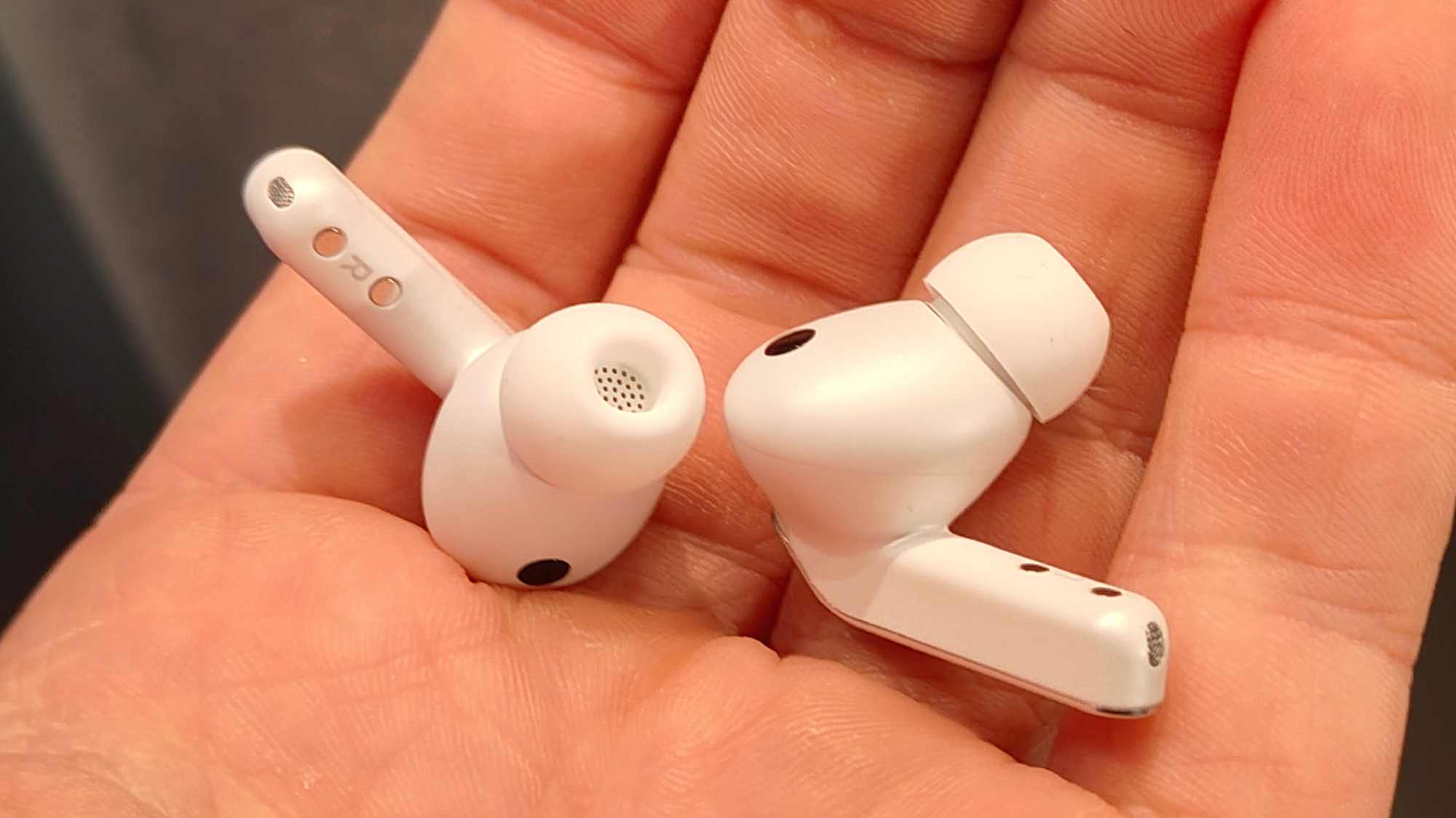 Two Samsung Galaxy Buds 4 Pro earbuds, in a man's hand.