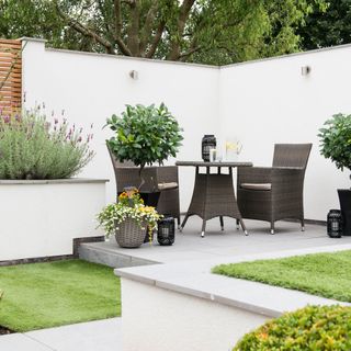garden with flowers in pots and grey round table with chairs