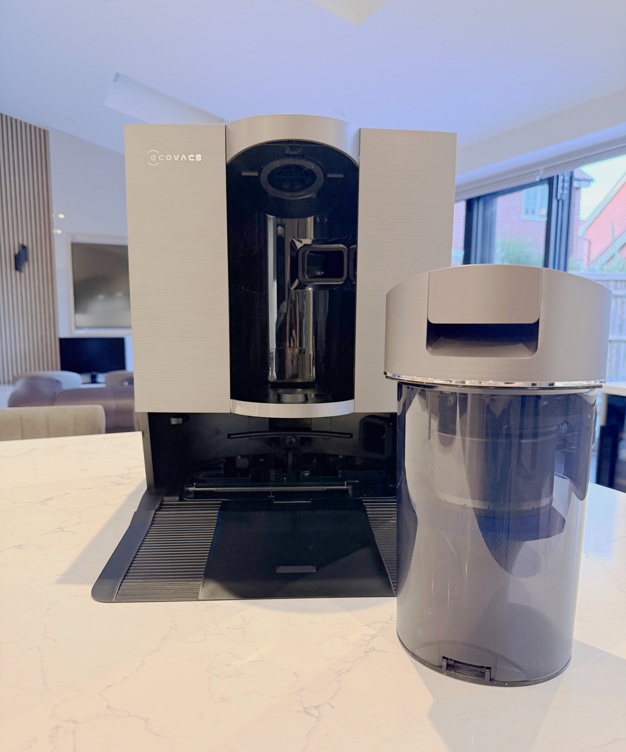 Reusable bagless dust container next to ECOVACS DEEBOT X11 OmniCyclone station