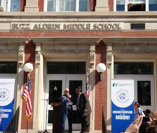 Apollo 11 moonwalker Buzz Aldrin and Ron Bolandi, Superintendent of the Montclair School Sys-tem, chat together under the new sign for the renamed Buzz Aldrin Middle School.