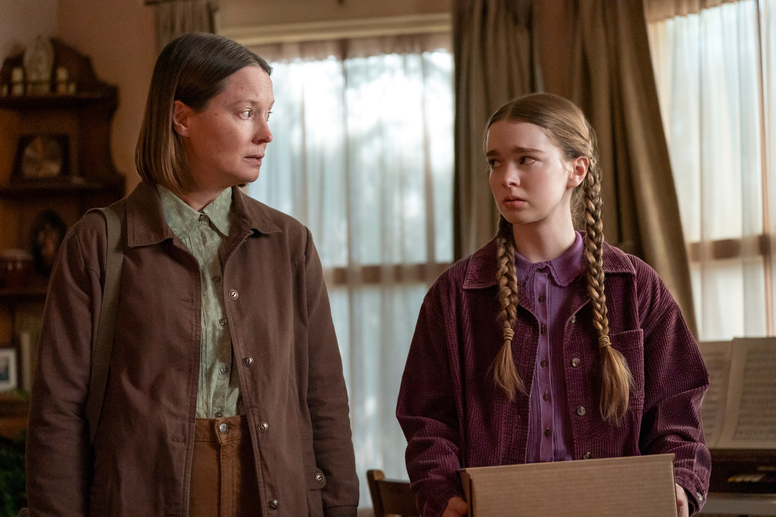 A mother (Samantha Sloyan as Margaret White) and her teenage daughter (Summer H. Howell as Carrie White) look at each other nervously while standing in a living room, in Prime Video's 'Carrie.'