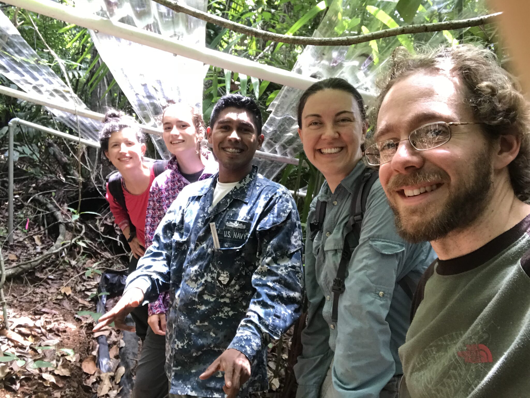 A group of five people pose for a selfie and smile at the camera in a tropical forest in Panama.